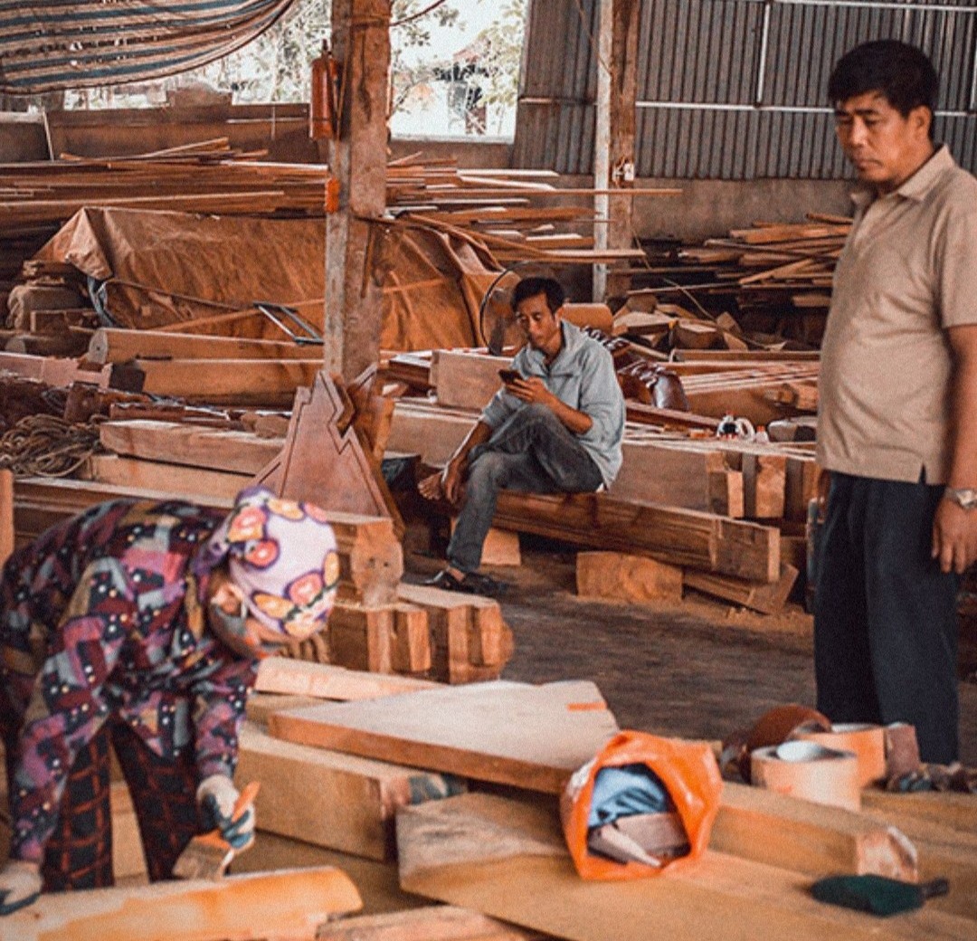 Ông Nguyễn Văn Minh (người bên phải) kiểm tra tại xưởng sản xuất đồ mộc của gia đình